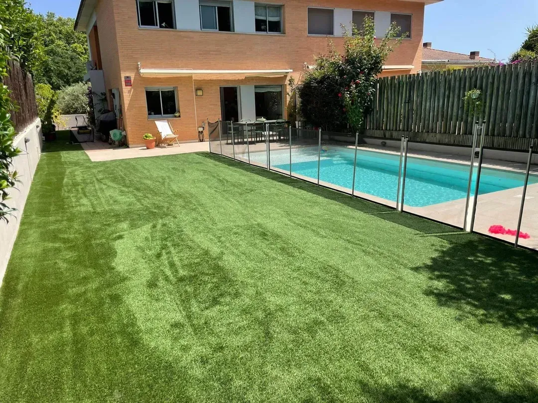 Jardín con piscina y césped artificial terminado en Sabadell